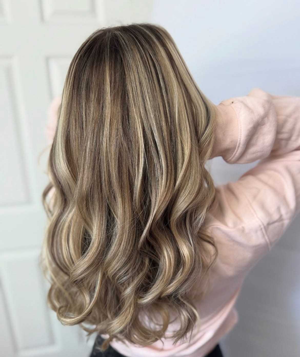 Long wavy hair with blonde highlights, viewed from the back.